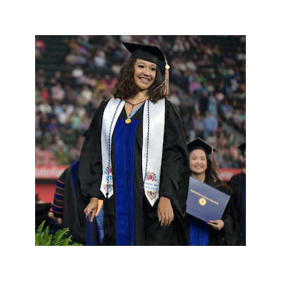 photograph of a woman at graduation with a white stole and graduation cap