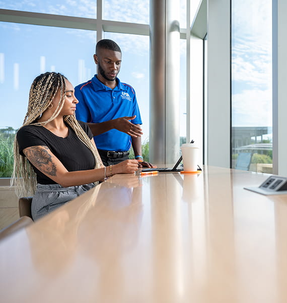 a male and a female talking next to a desk