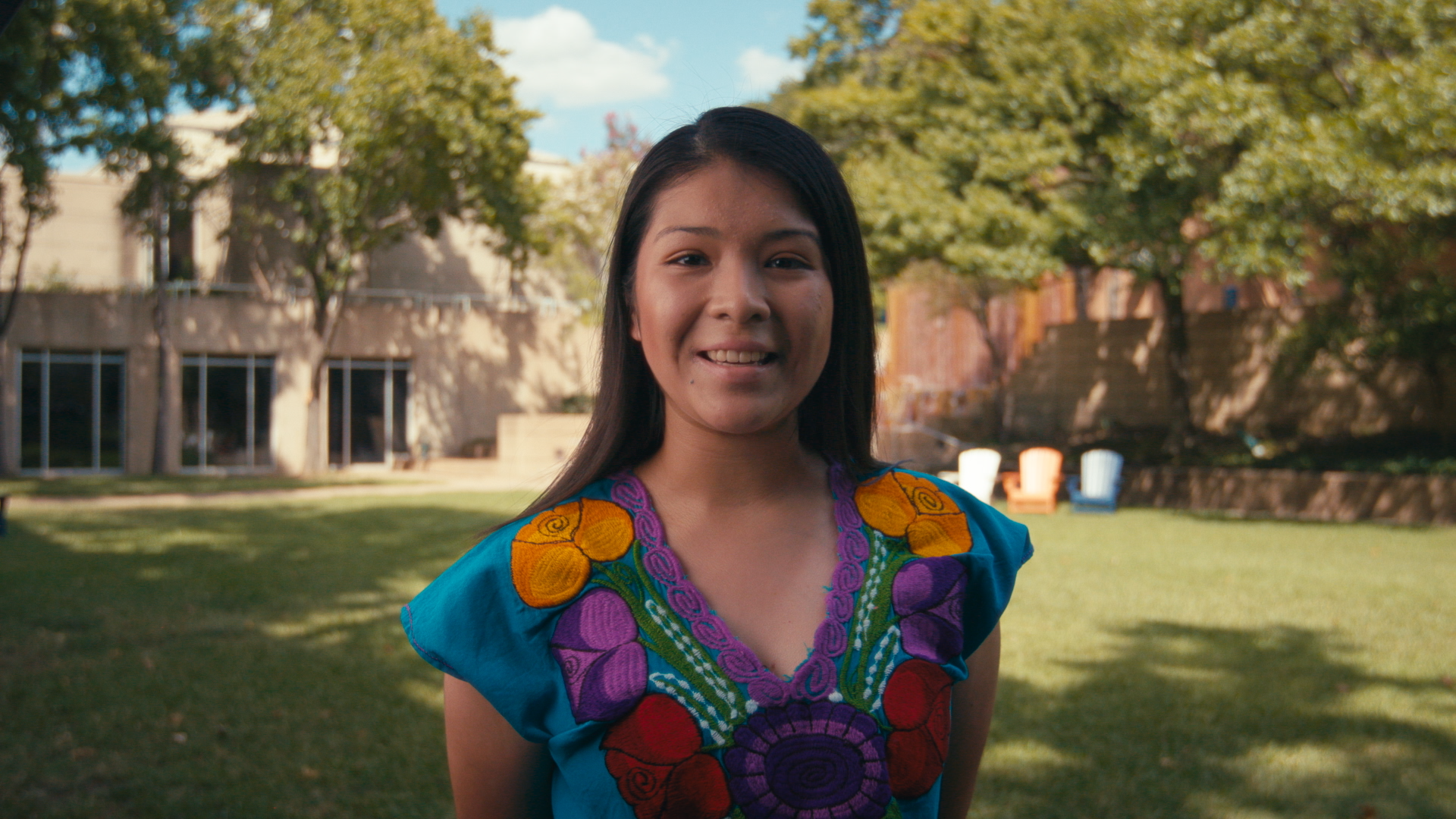 A Hispanic woman in a colorful dress