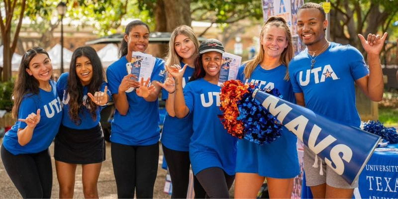 a group of students giving the mavs up hand sign