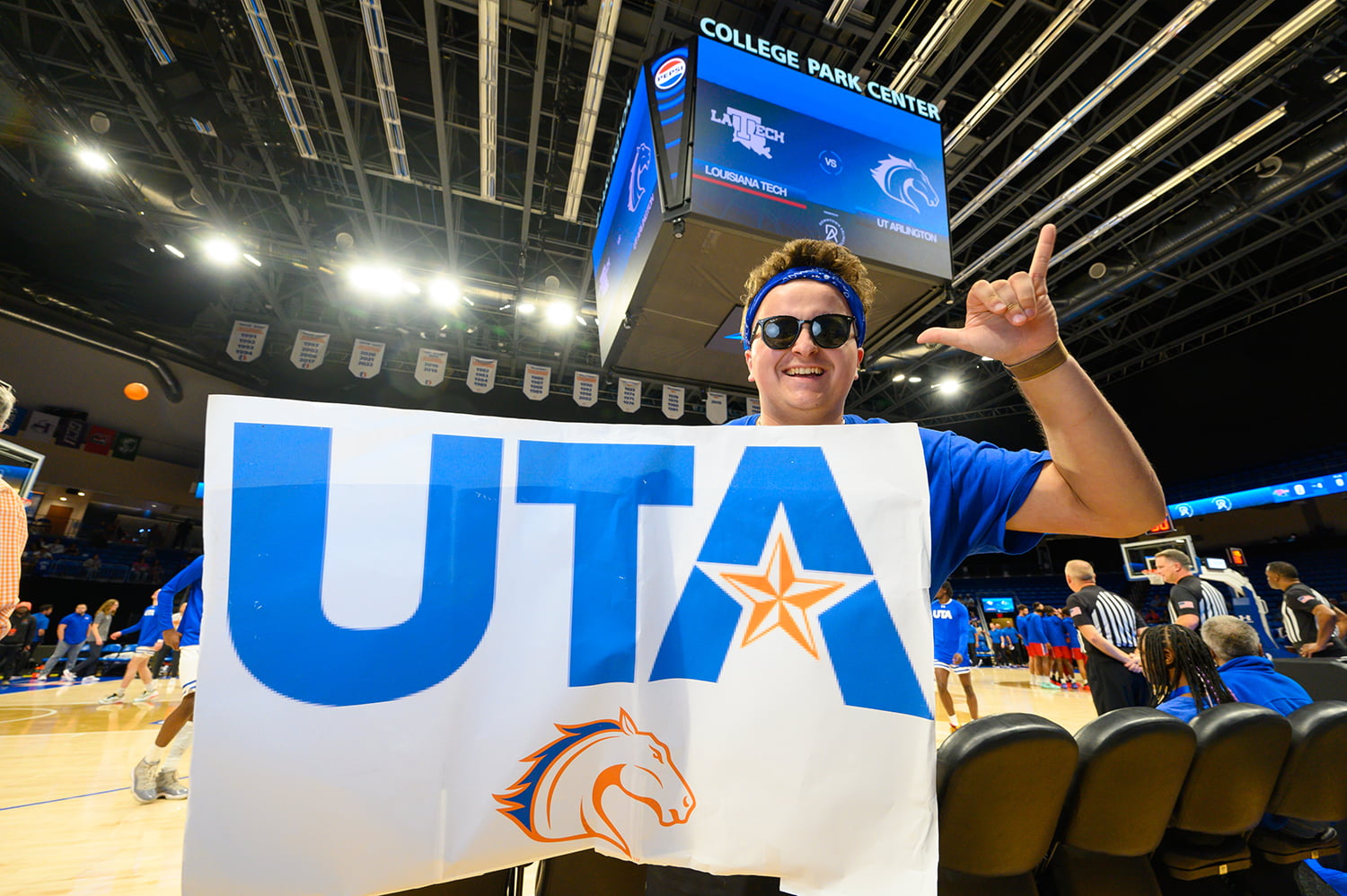 a student holding up a large sign that says U T A