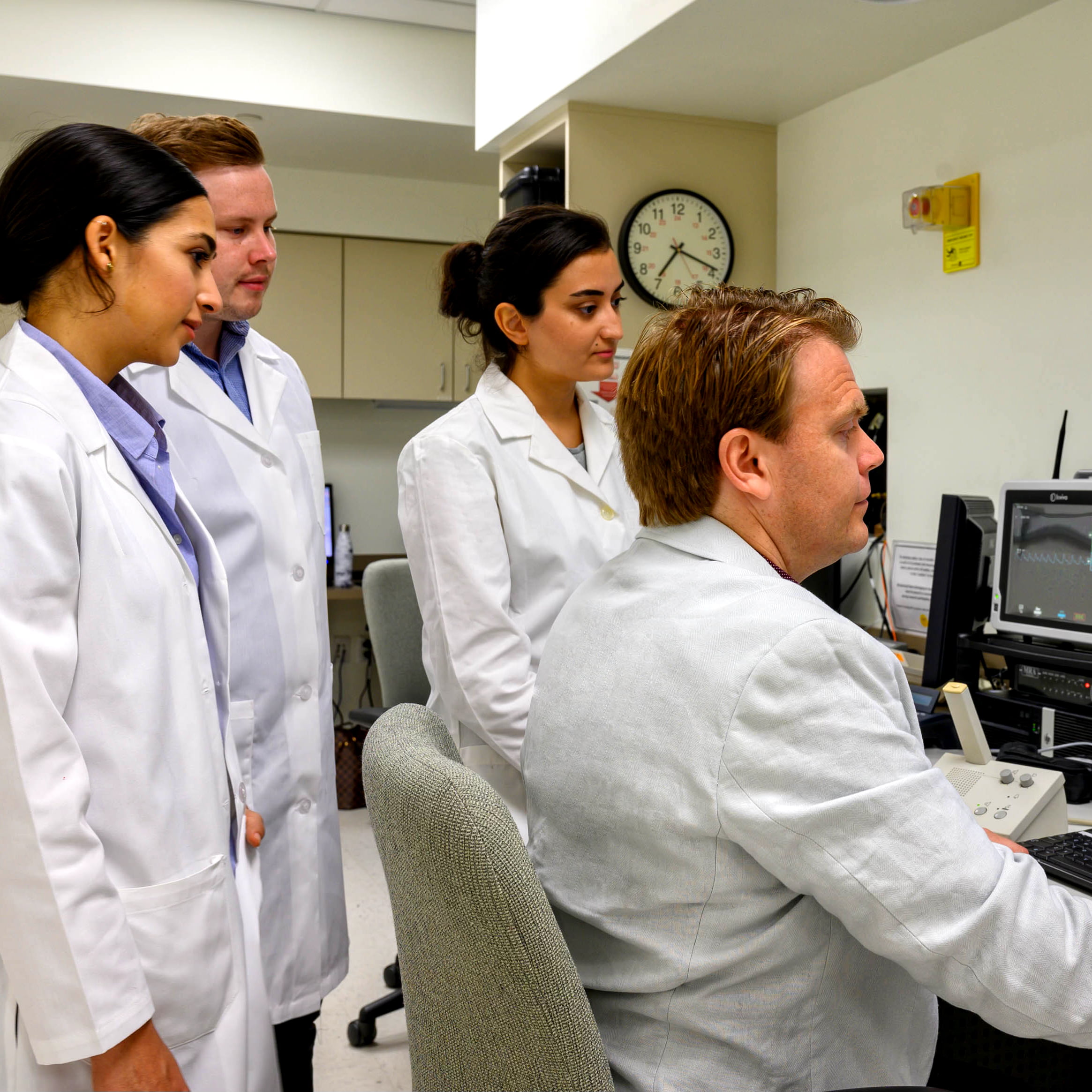 a group of researchers in lab coats working in a lab