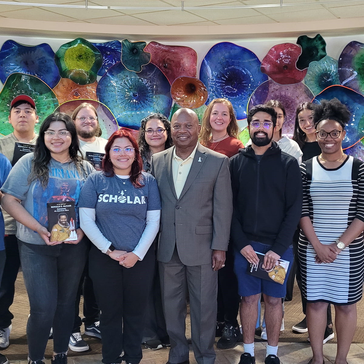 A group of UTA's McNair Scholars standing with founder Carl McNair.