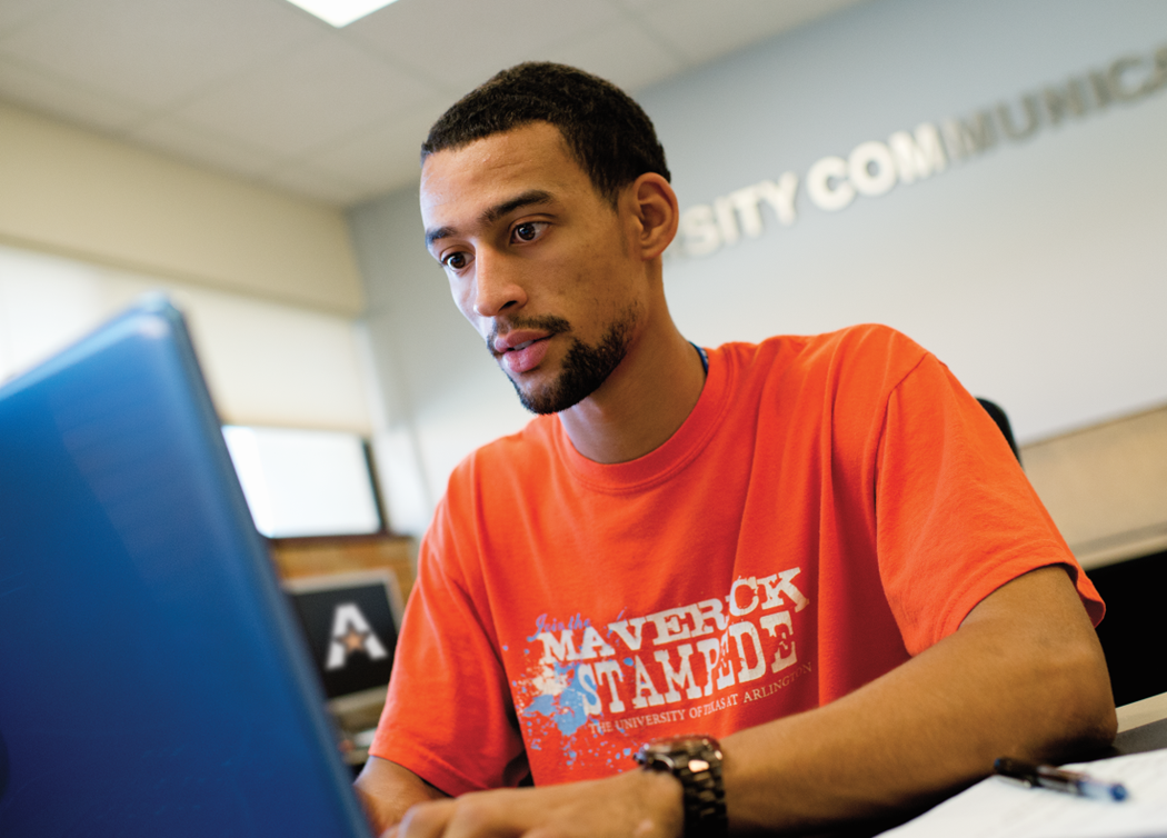 UTA student sitting at a laptop computer