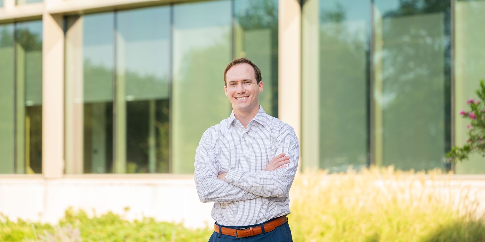 A cheerful man wearing a light blue dress shirt smiles for a portrait." _languageinserted="true