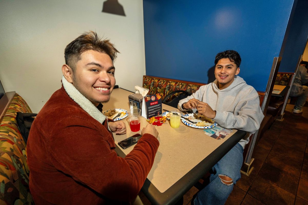 Two students seated at the UTA Thanksgiving dinner