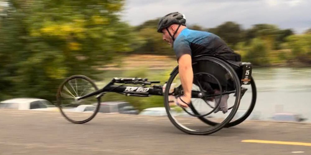 Tyler Garner, UTA sports nutrition expert, competes in triathlon on his bicycle" _languageinserted="true
