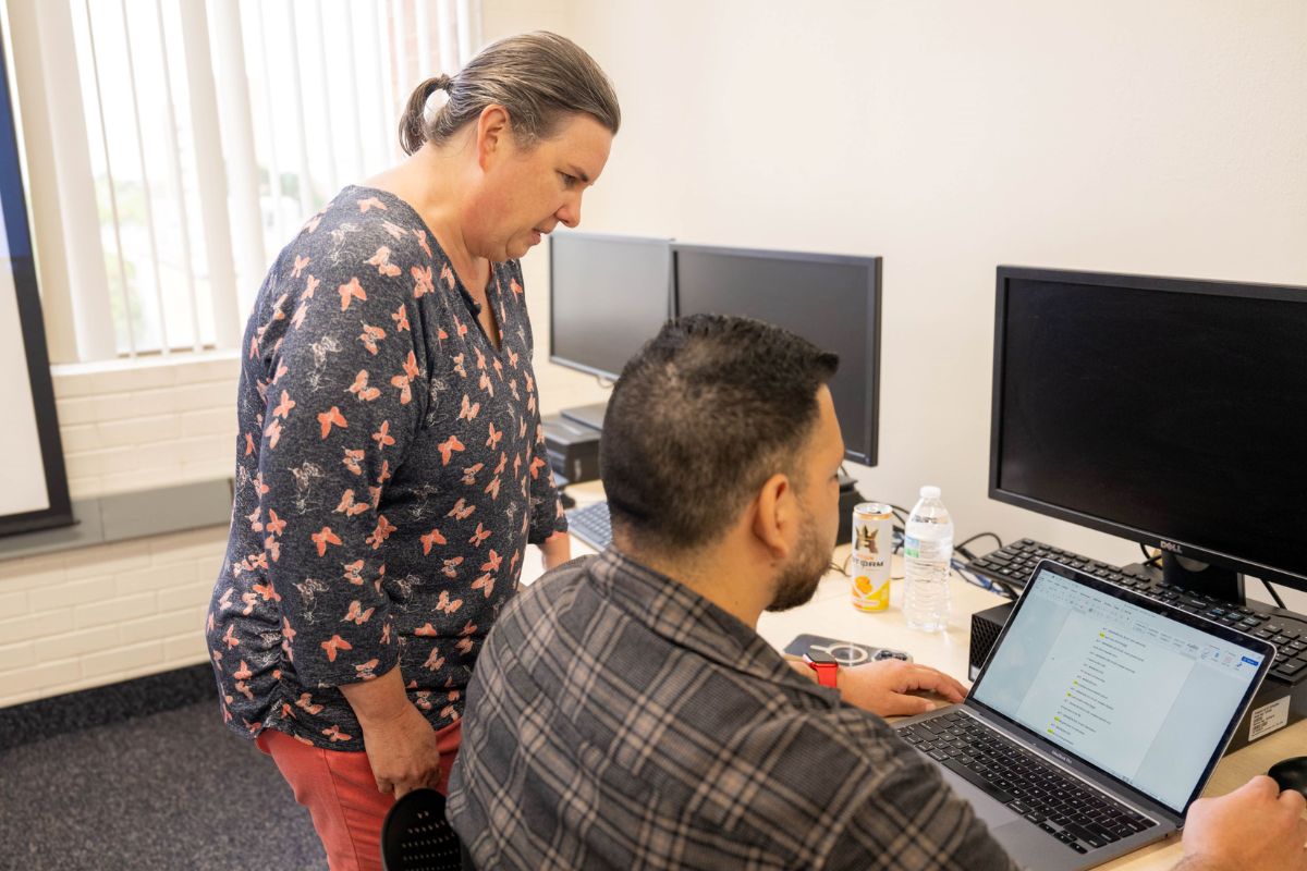 Teacher leaning over student in a computer lab