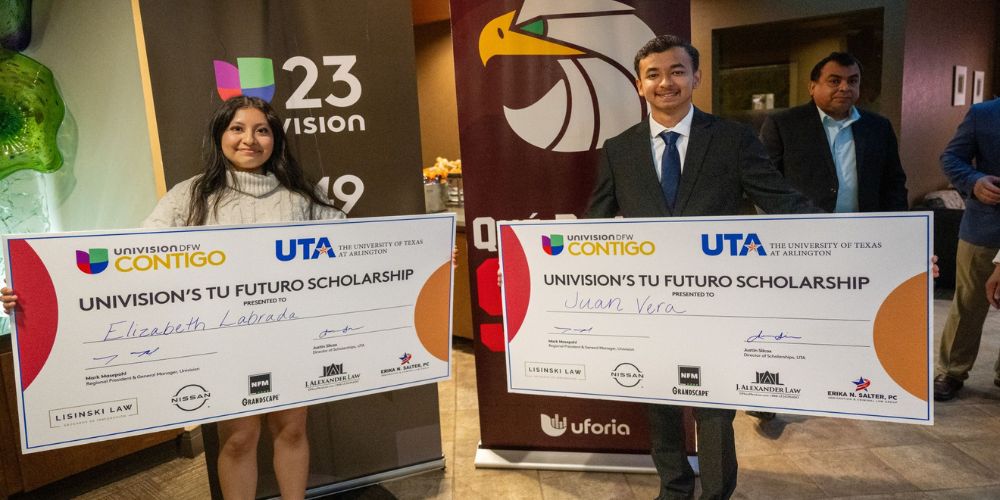 Elizabeth Labrada and Juan Vera holding large checks