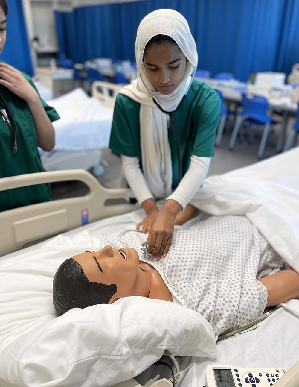 Students learned basic clinical skills including checking patient vital signs. Photo courtesy of Steve Gellman." _languageinserted="true