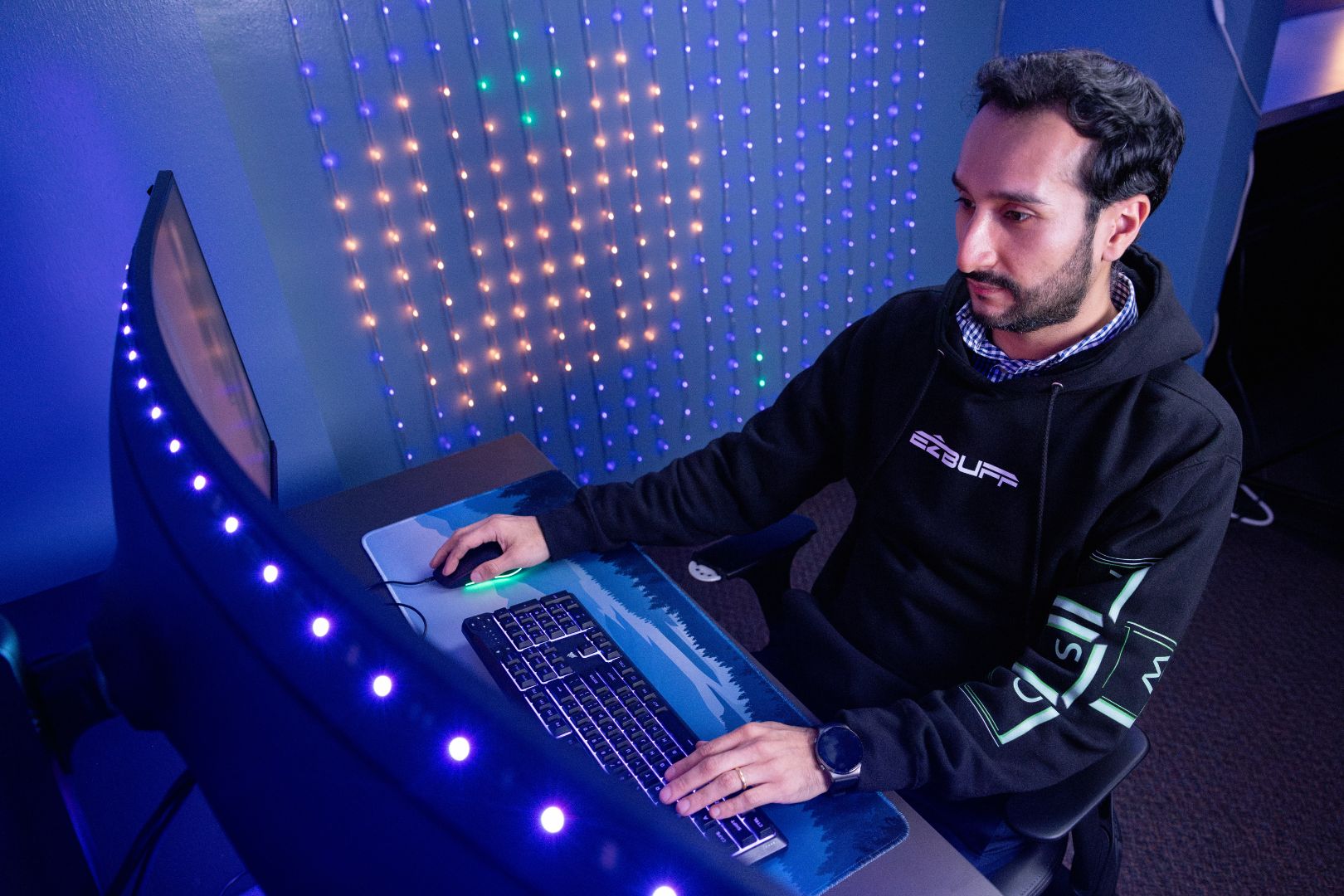 Image shows Felipe Quinteros wearing one of his EZBUFF hoodies while playing a game on a PC