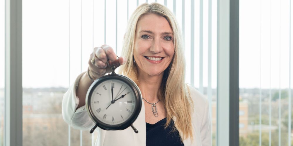 Christine Spadola holding a clock " _languageinserted="true