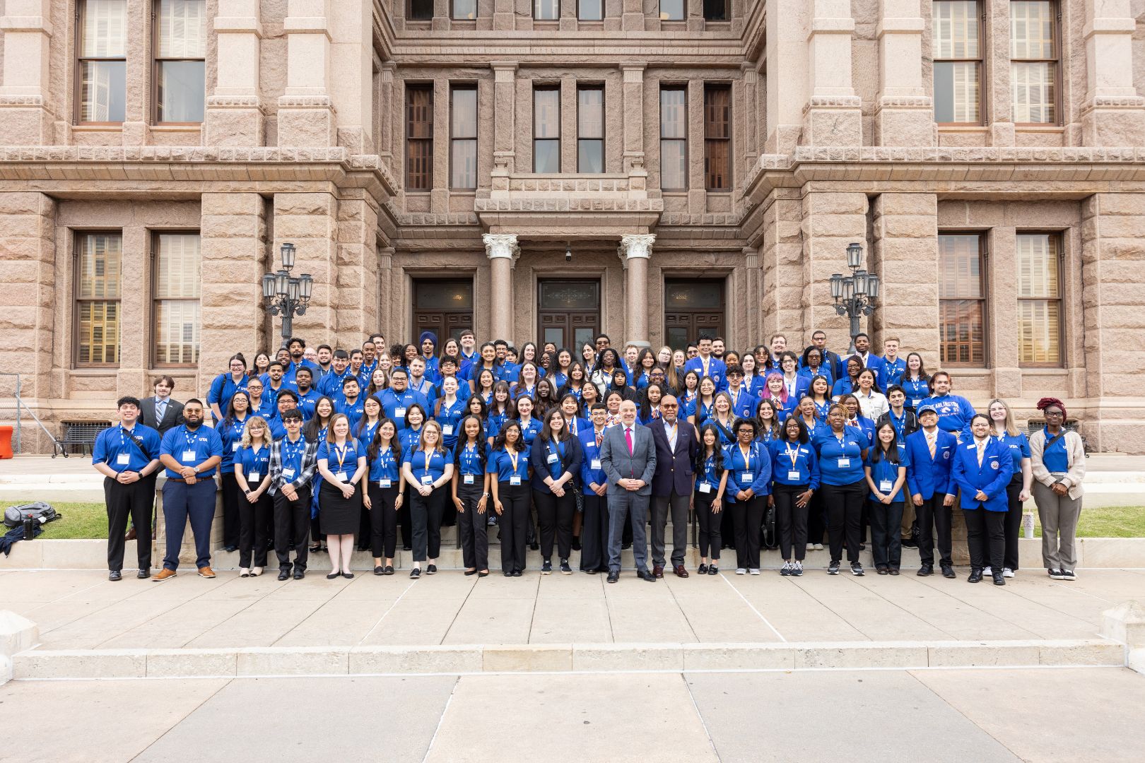 Image shows a group photo of UTA students outside the Texas State Capitol 