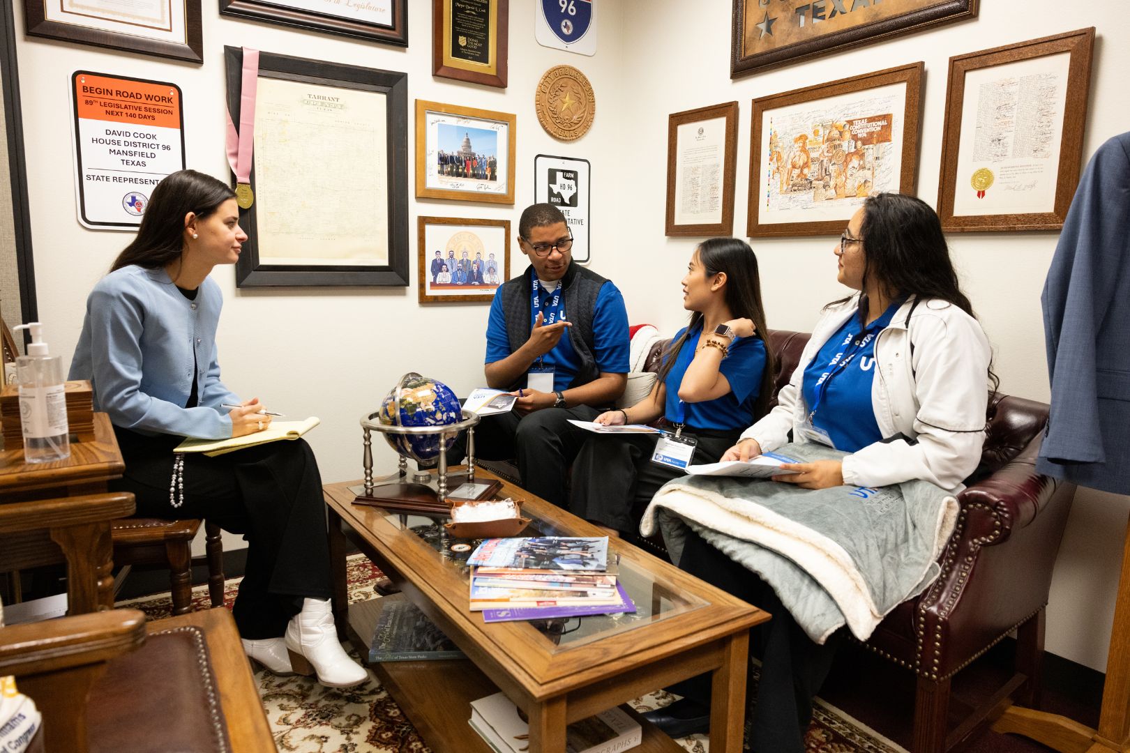 Image shows UTA students speaking with a Texas Legislature staffer during UTA Day at the Capitol