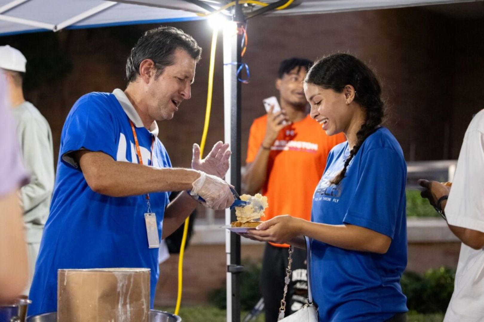 Image shows UTA student receiving a waffle at Waffleopolis