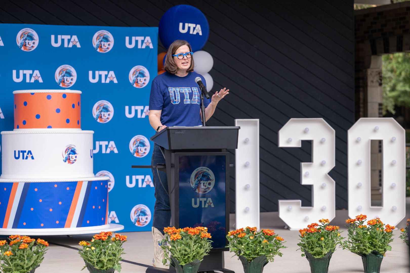 Image shows UTA President Jennifer Cowley addressing the UTA community at Brazos Park during the 130th Birthday Bash" style=" height:1080px; width:1620px" _languageinserted="true" src="https://cdn.prod.web.uta.edu/-/media/project/website/news/releases/2025/09/birthday-bash-main-(1).jpg