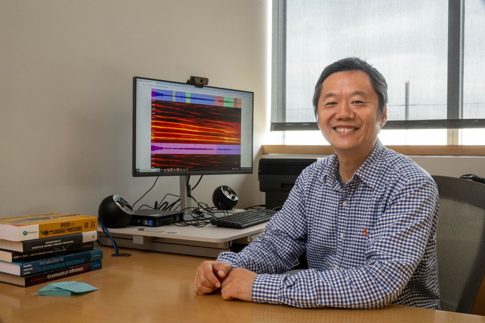 Image shows Dr. Kenny Zhu sitting at his desk 