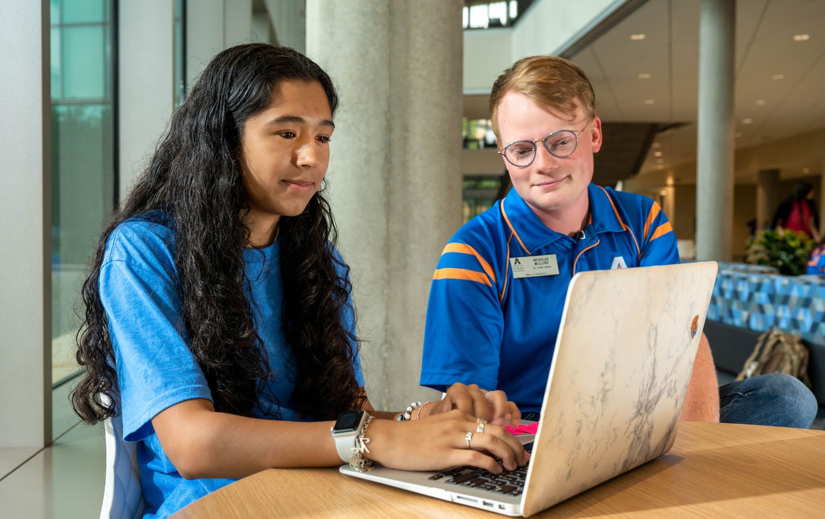 Two people looking at a laptop screen 