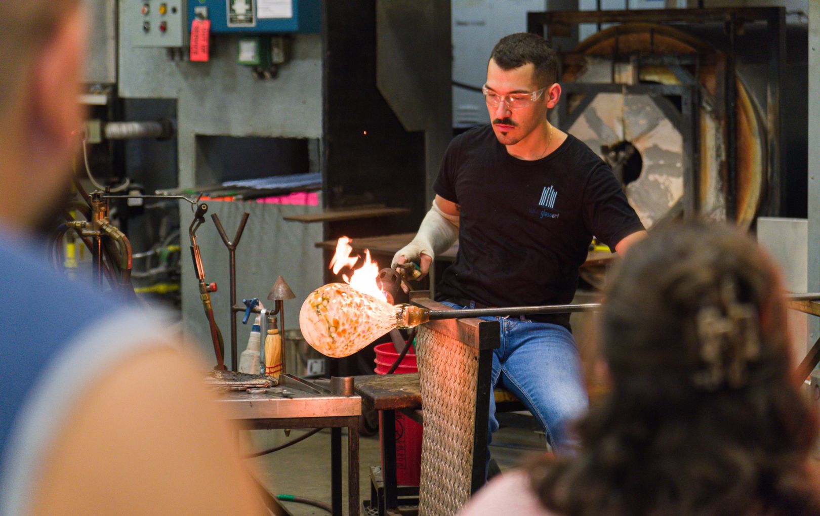 UTA student holding glassblowing demonstration 