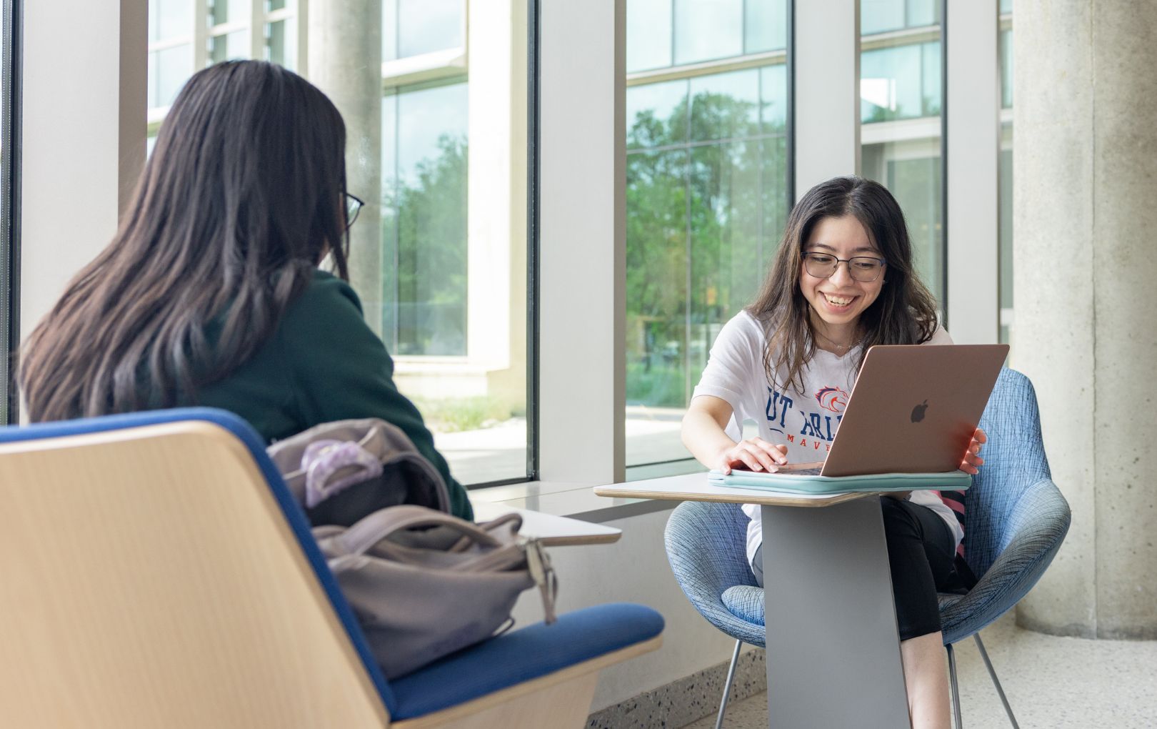 Two UTA students looking at laptop screen