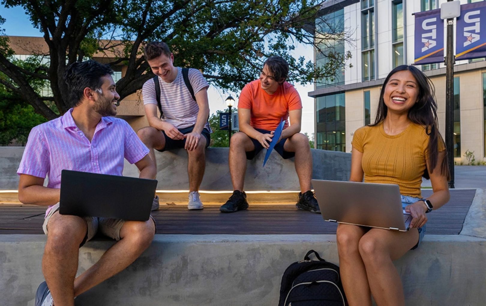 Four UTA students sitting outside studying 