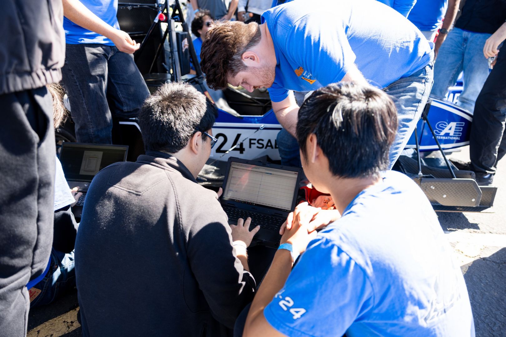 Image shows UTA Racing team members work on a car before it races on the track