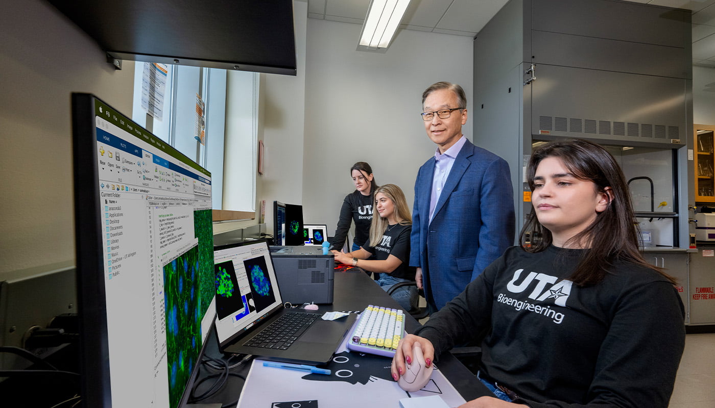 a professor and student sitting in front of a computer