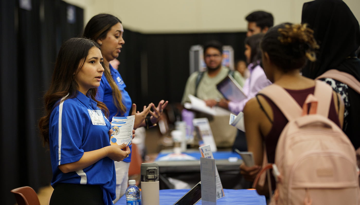 an employer hands out information at a career fair