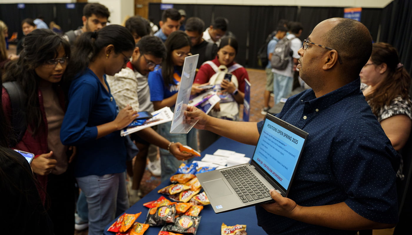 a man speaks to prospective students at a career fair