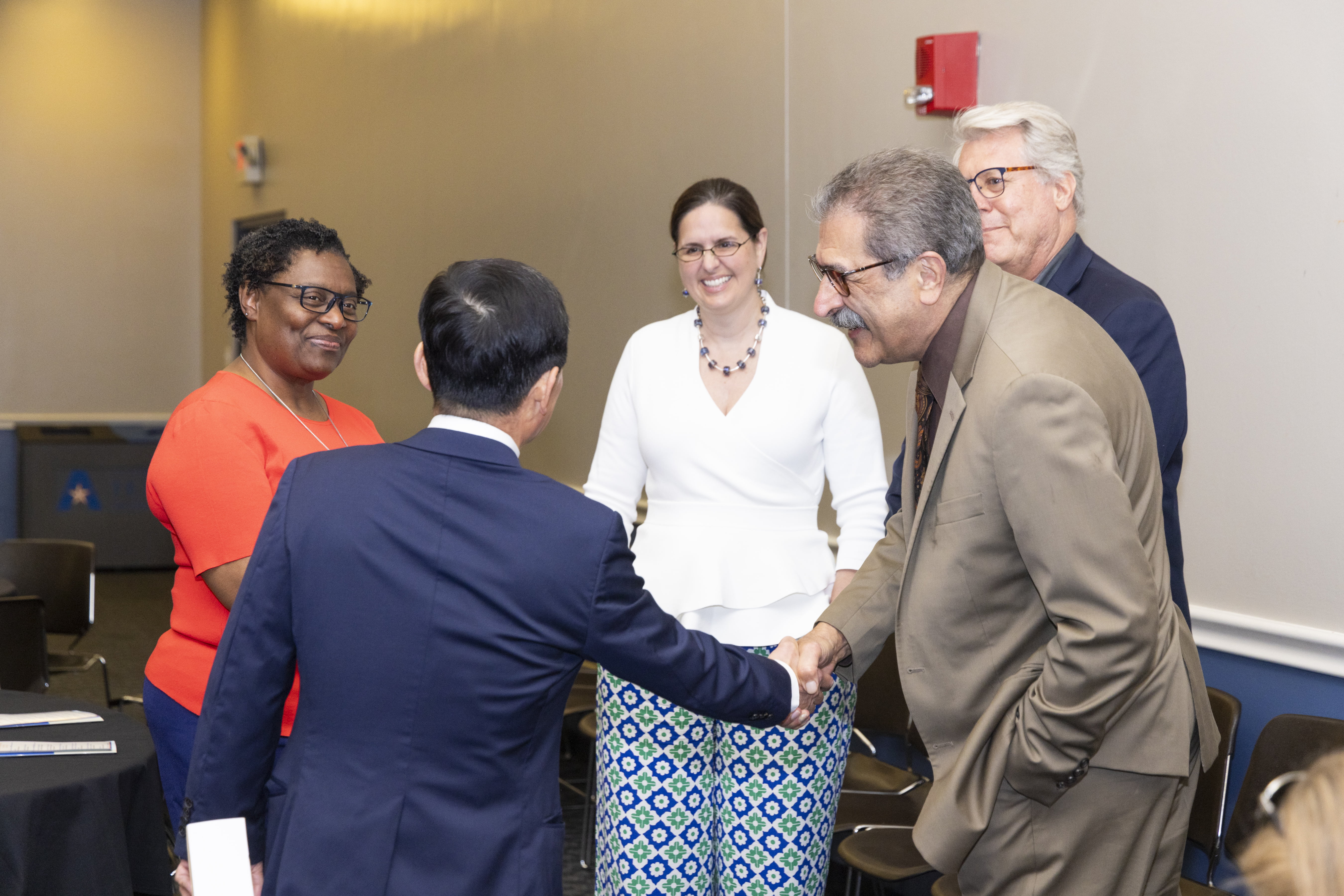 UTA Faculty and Associates smile and greet each other.