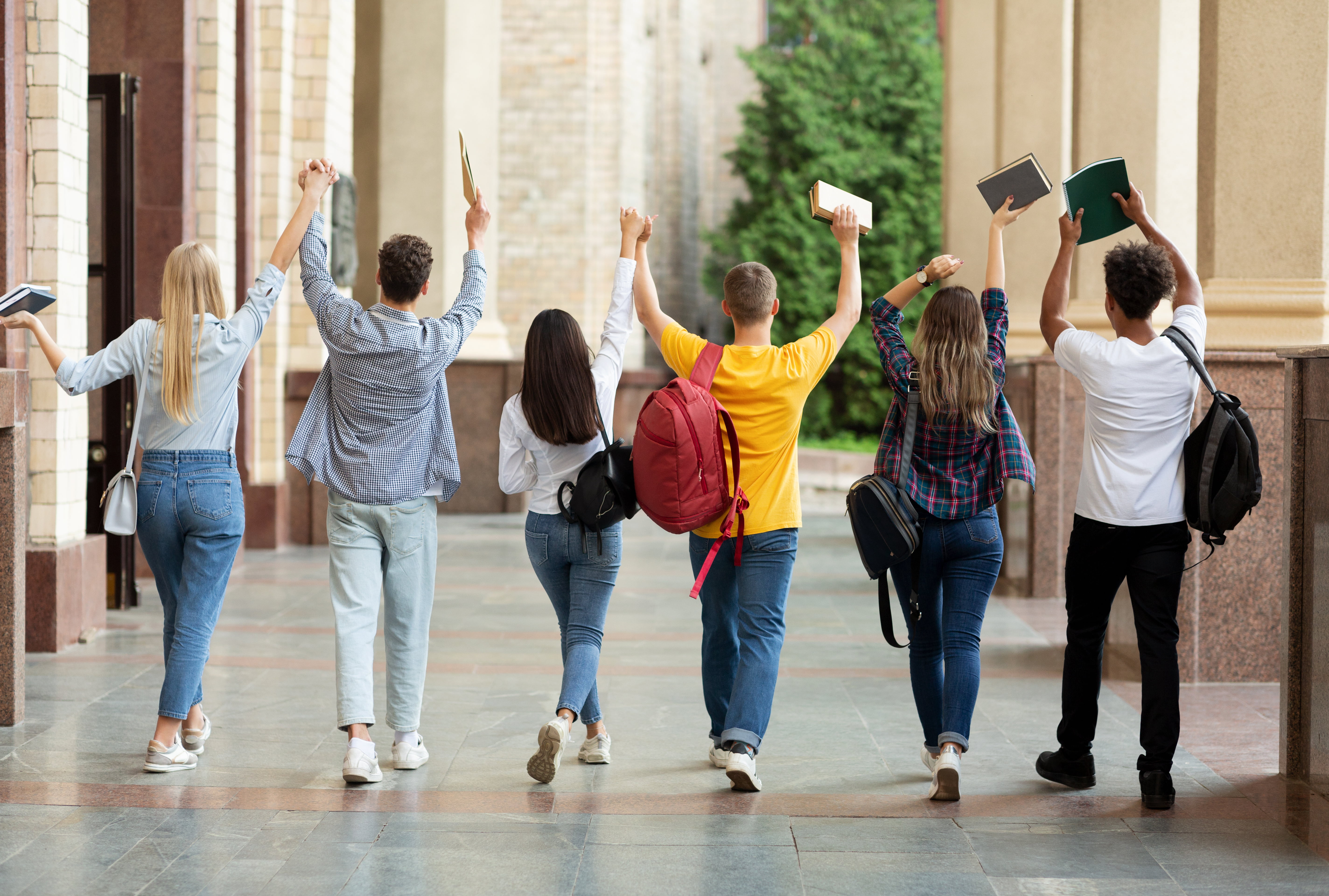 Student walking together raising their hands
