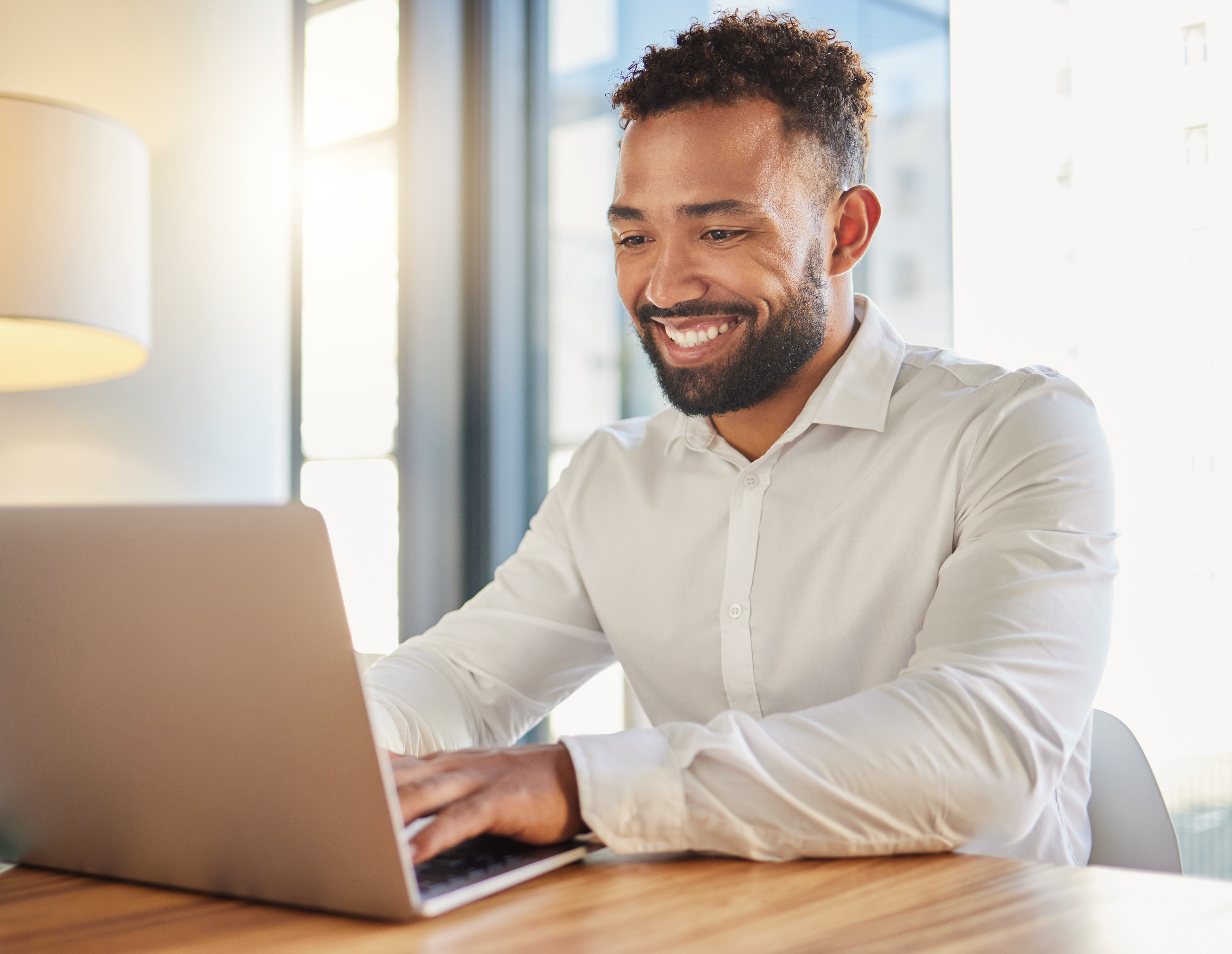 A man happily working in his laptop