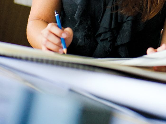 UTA faculty member writing notes while developing a research proposal