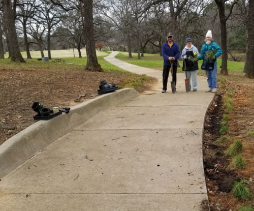 A trio of planters pose with their seedlings at Randol Mill Park