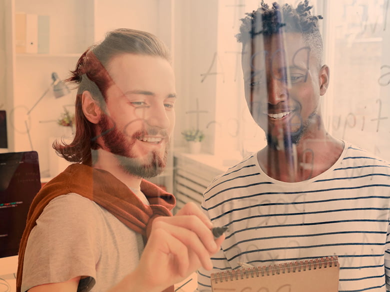 Two students studying by brainstorming on a transparent board