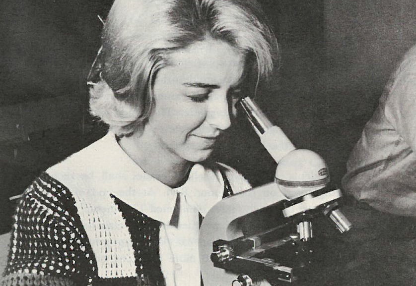 A biology student uses a microscope in 1965, the year the College of Science was formed.