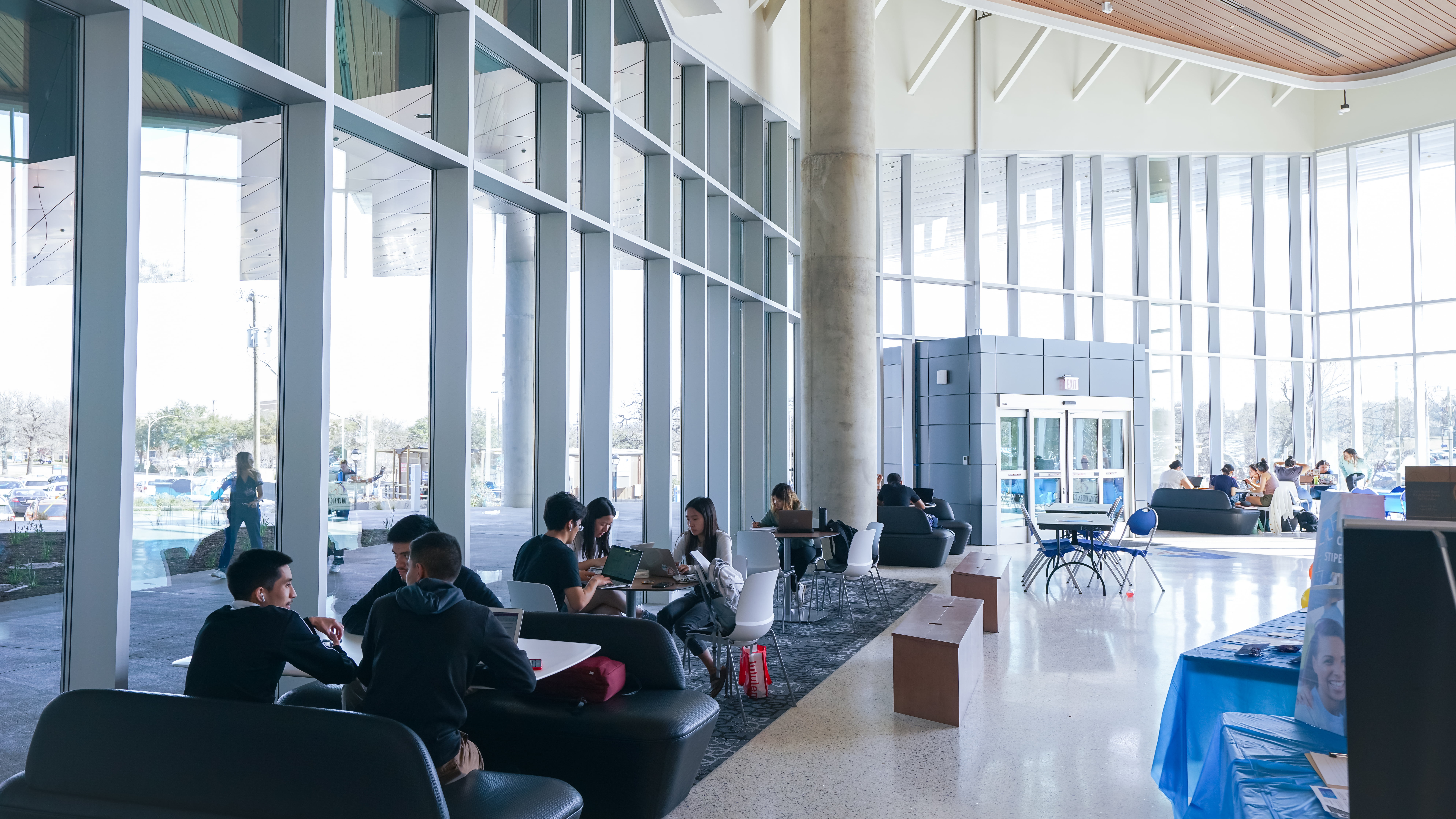 Students sitting in the lobby area during the Open House of the School of Social Work & Smart Hospital building