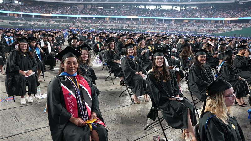 UTA graduate students sitting in their chair during Spring 2025 Commencement