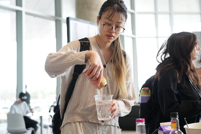 A UTA student pouring a drink of soda during the STARR Lab: Saddle Up Soda Bar event.