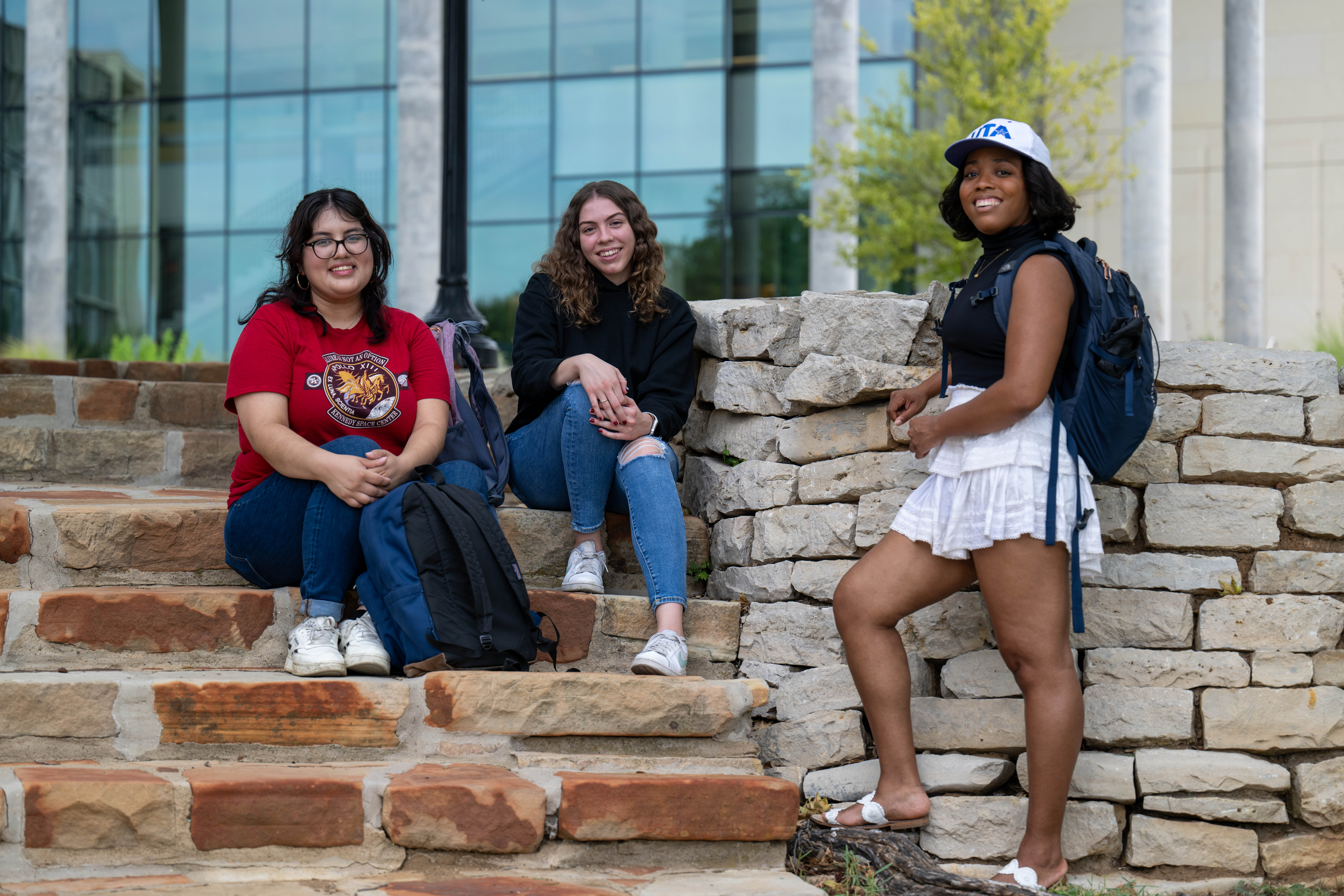 UTA students sitting on the steps during a college tour.