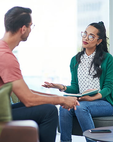 A man speaking with a therapist in a green jacket.