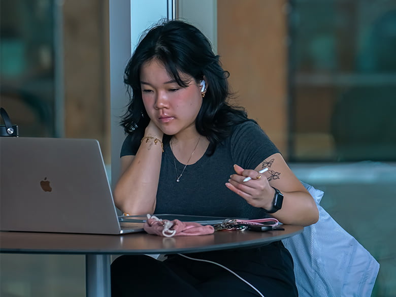 UTA student sitting at a table doing research