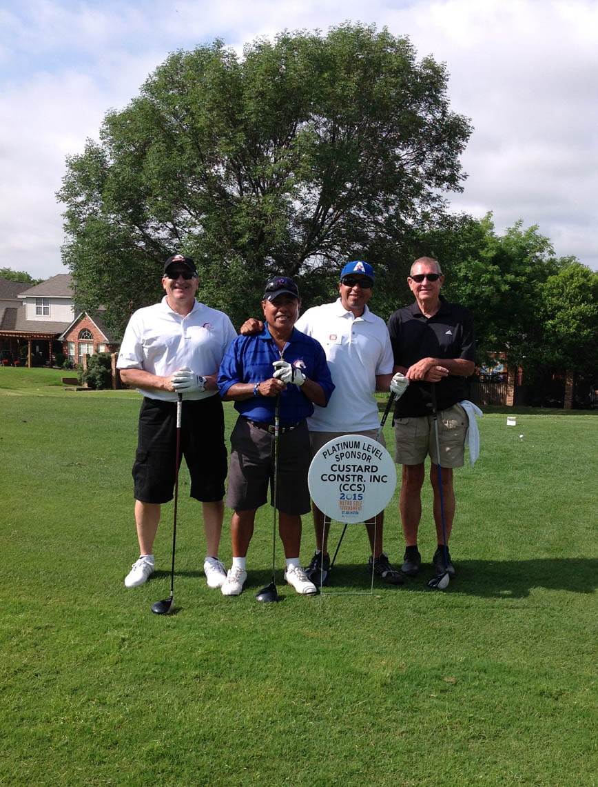 Participants of the Golf Tournament grouped with the event sign