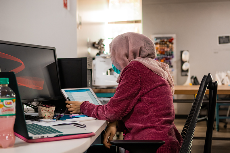 A person studying at the library on a computer