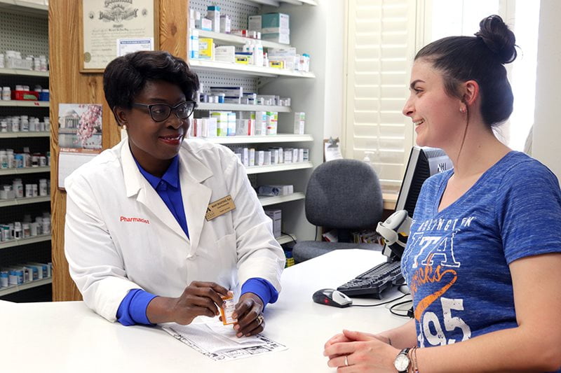 A person sitting at a desk with a pharmacist