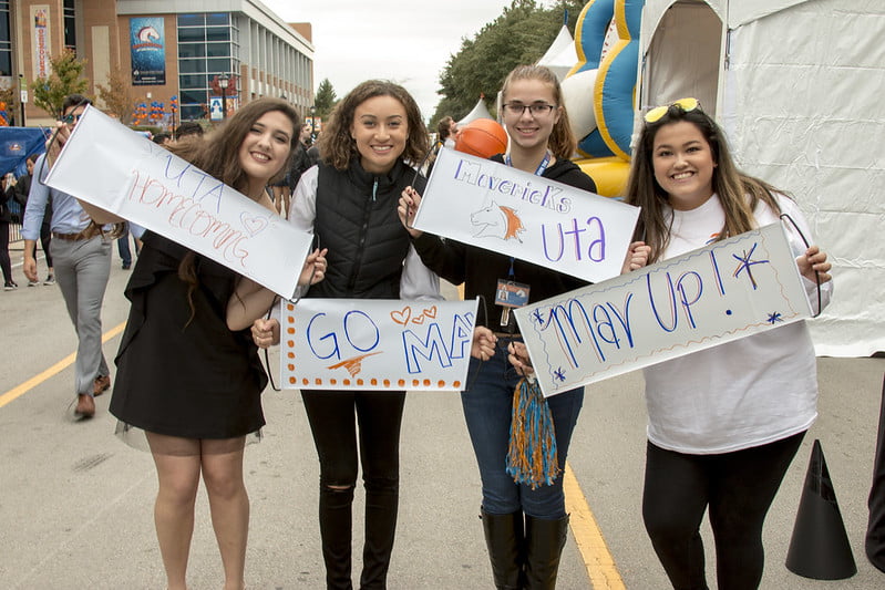 four women holding mav up signs