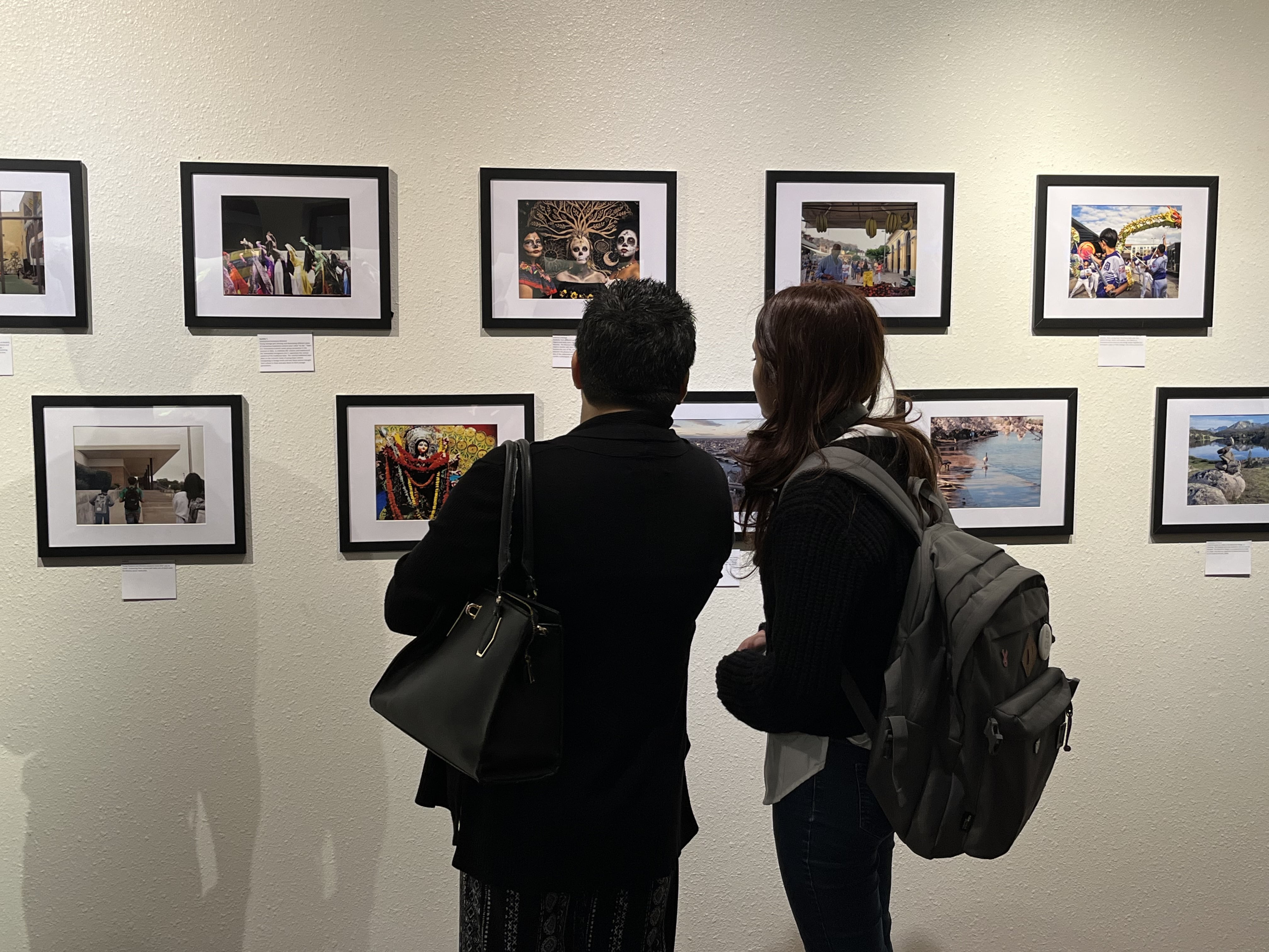 two persons viewing art on the wall at an art exhibit