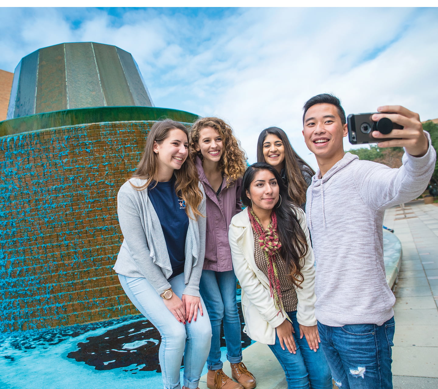 A group of students outside near the UTA water fountain
