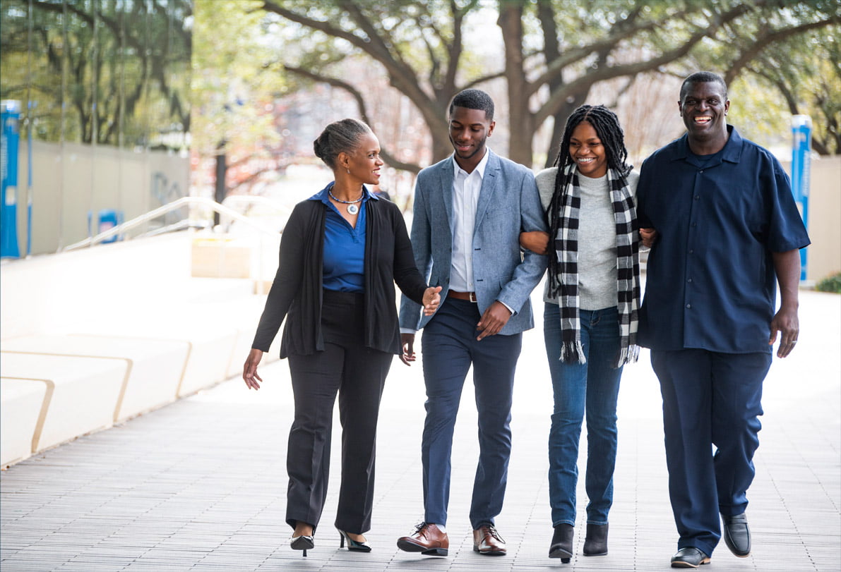 The Morralls and their son and daughter walking through campus together.