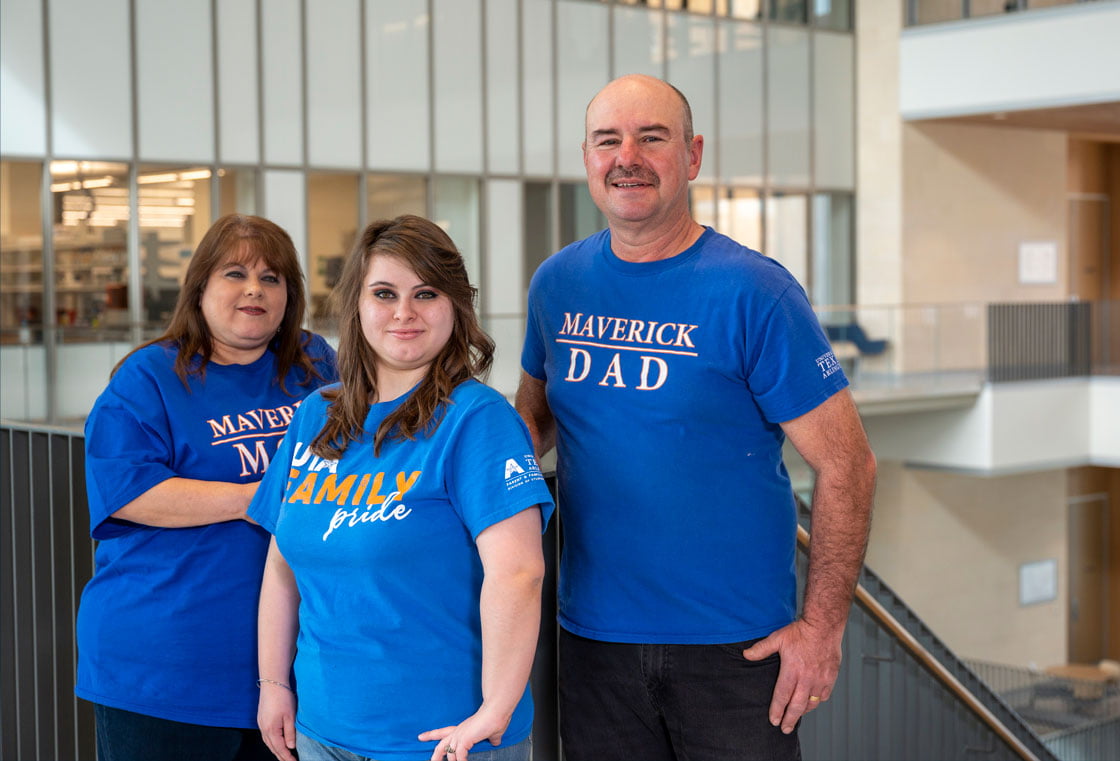 The Richards and their daughter posing in the SEIR Building